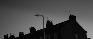Roofline of Victorian rowhouses in Knaresborough, with TV antennas and modern street light.